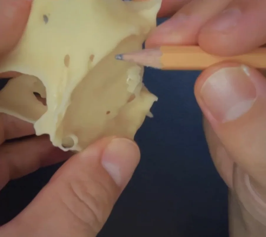 Lápis contornando a entrada da osteotomia no protótipo impresso
